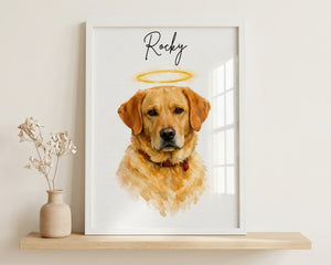 A framed custom pet portrait print featuring a golden retriever with a halo and the name 'Rocky' written above, displayed on a light wood shelf next to a small vase with dried flowers against a beige wall.