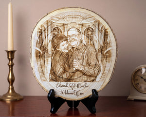 A round wood slice plaque with a custom engraved portrait of a couple and the text 'Edward & Martha 30 Years Of Love', displayed on a black stand on a wooden surface with a candle and clock in the background.