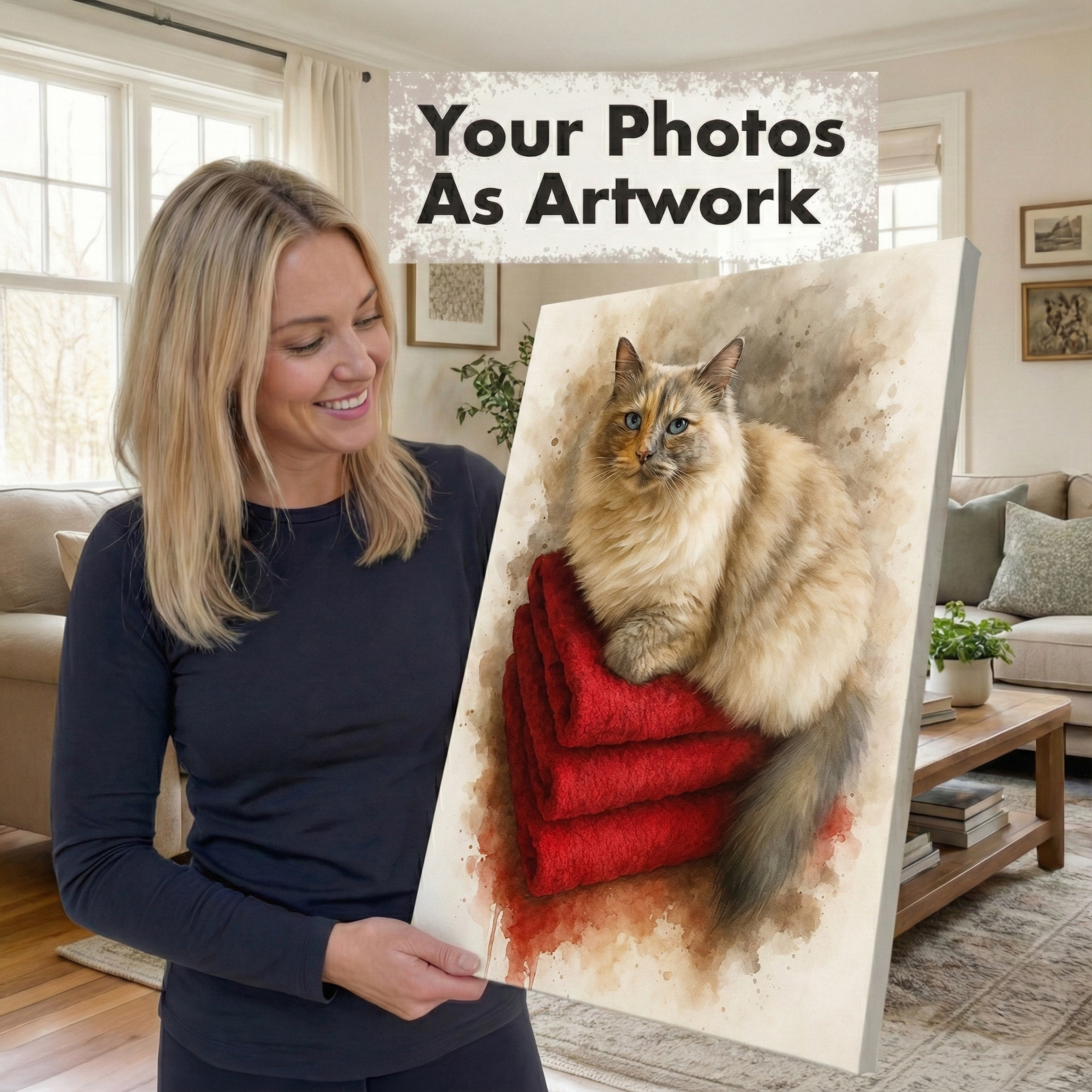A woman in a navy long-sleeve top holds a canvas painting of a fluffy cream-colored cat resting on red folded blankets. The scene is set in a bright, modern living room.