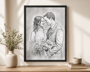 A framed black-and-white wedding sketch print hanging on a beige wall above a wooden shelf, styled with a ceramic vase of greenery on the left and a small cup and books on the right.